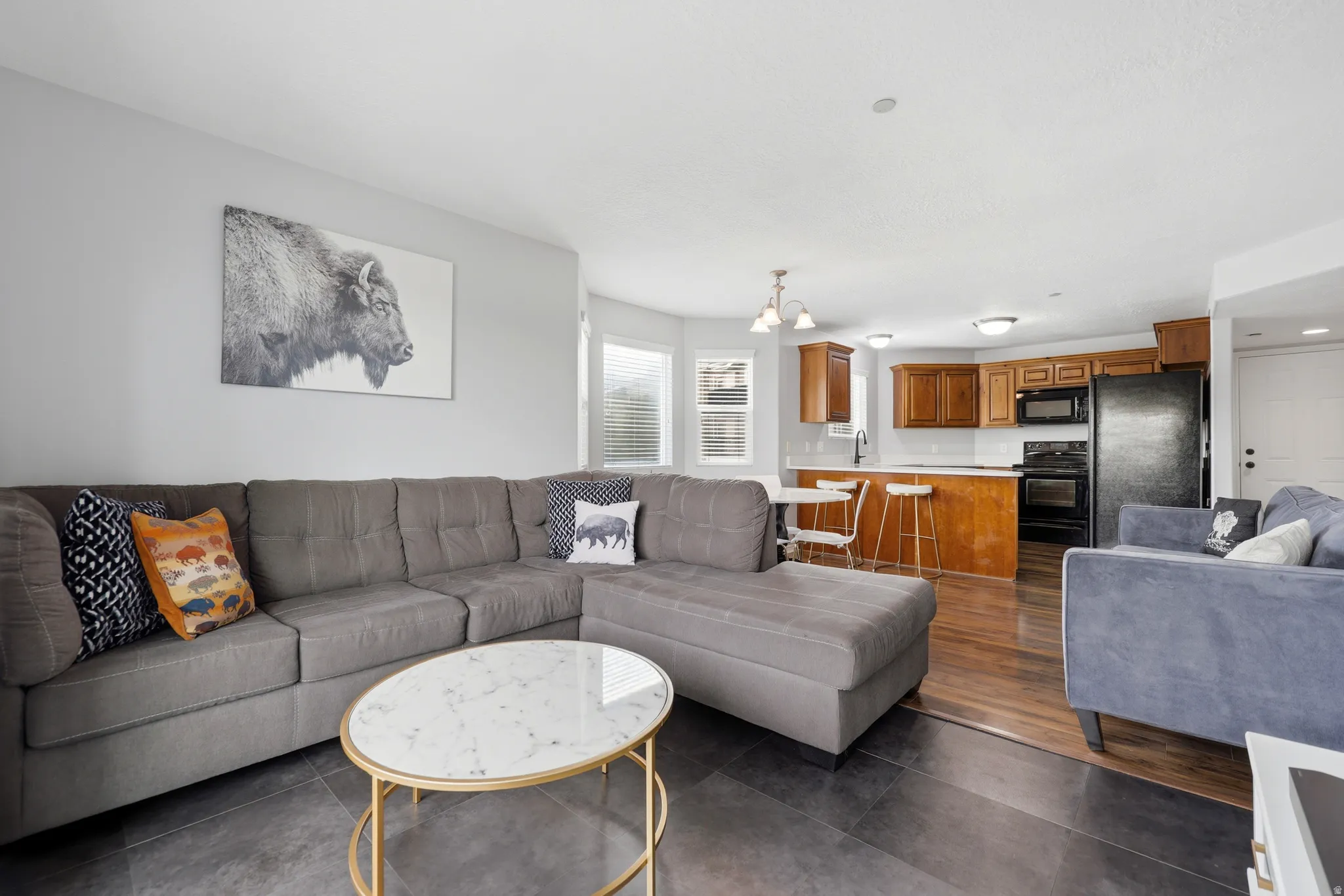 Open-concept living space featuring dark tile flooring and light grey walls