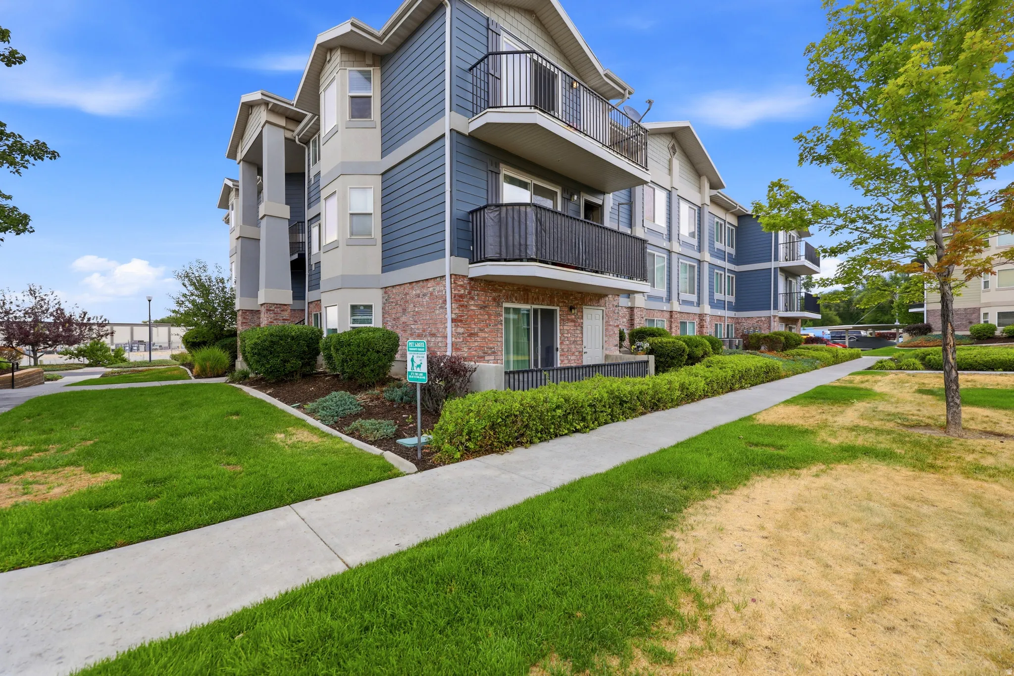 Multi-story building with blue siding, brick accents, and light-colored trim