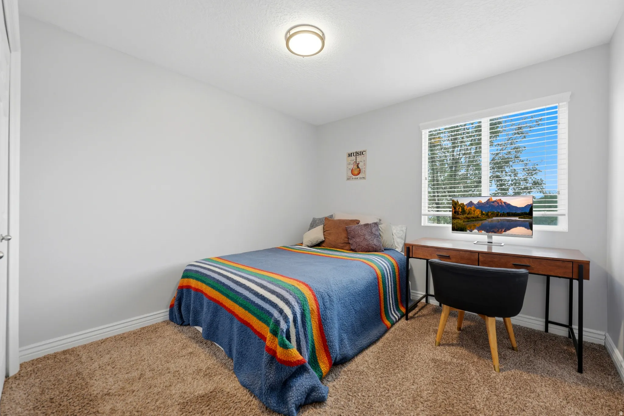 Bedroom featuring neutral wall paint, carpet flooring, a single window with blinds, and a flush mount ceiling light fixture