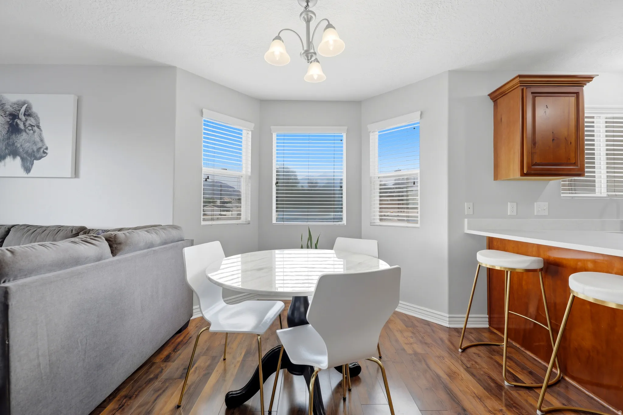 Dining area featuring wood-finish flooring, a white round table, and a contemporary ceiling fixture