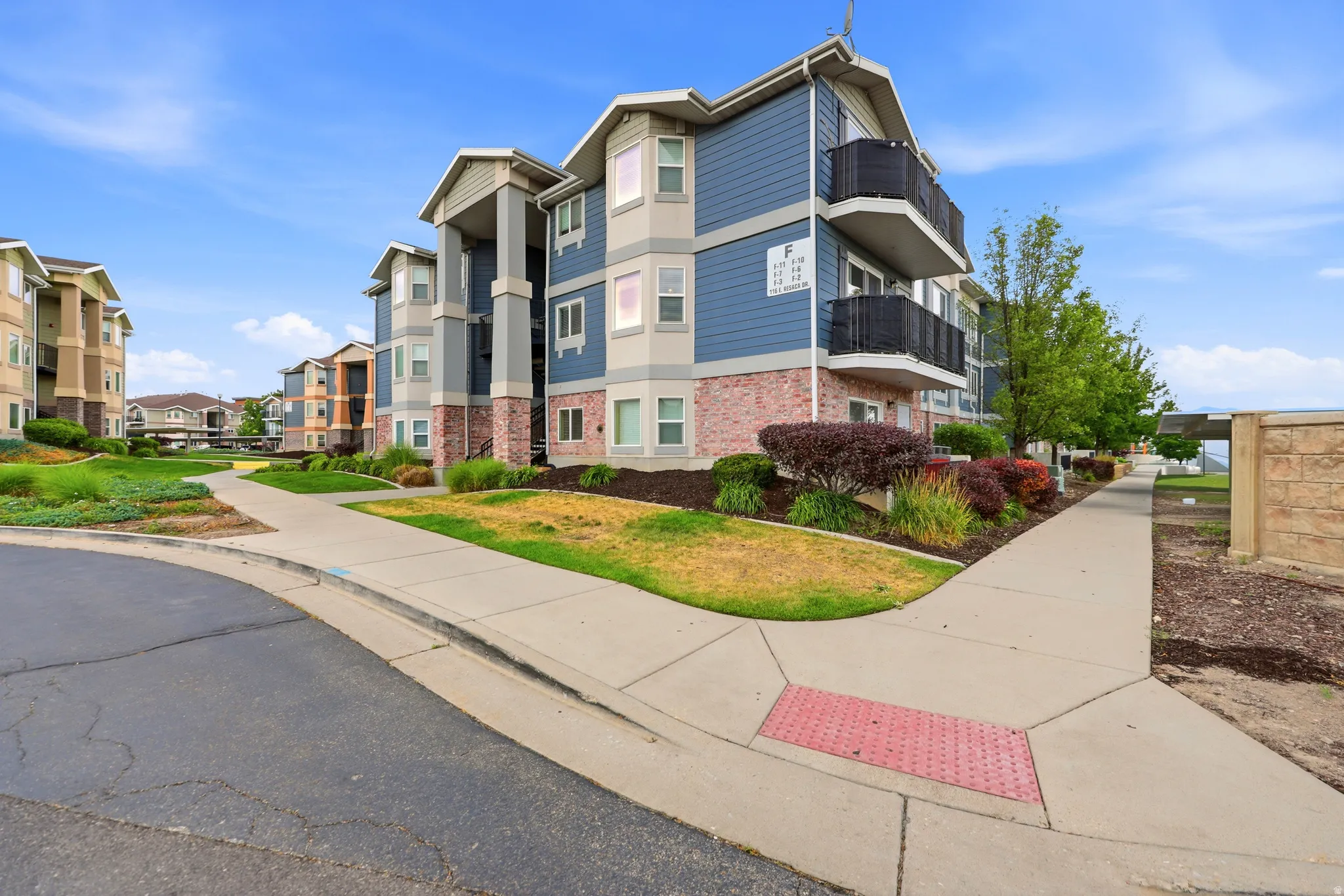 Multi-story residential building with blue siding and brick veneer