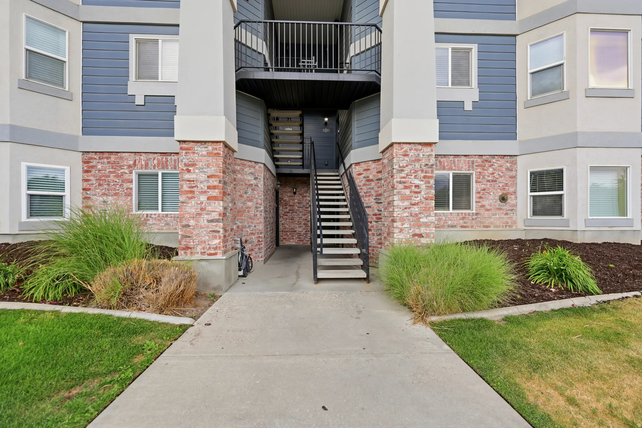 Multi-level building exterior featuring brick and siding accents