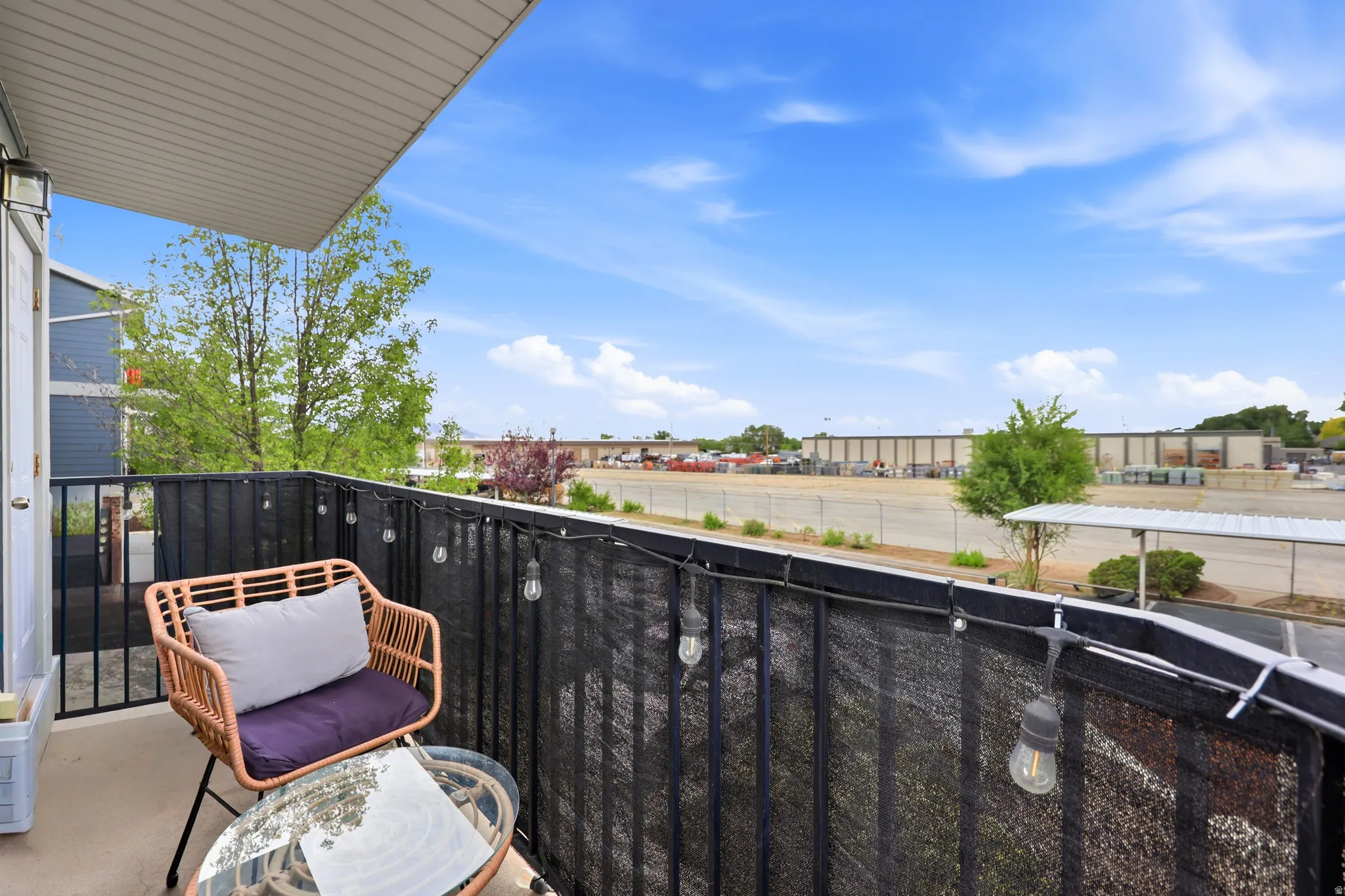 Outdoor balcony featuring a black metal railing and privacy screening