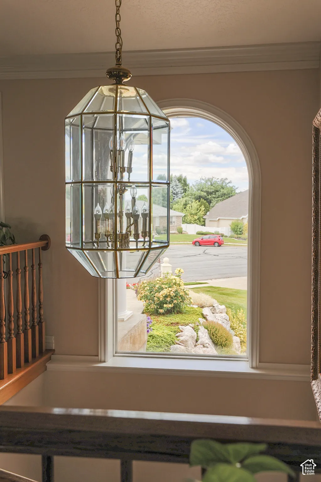 Ornate brass and glass chandelier illuminating an arched window