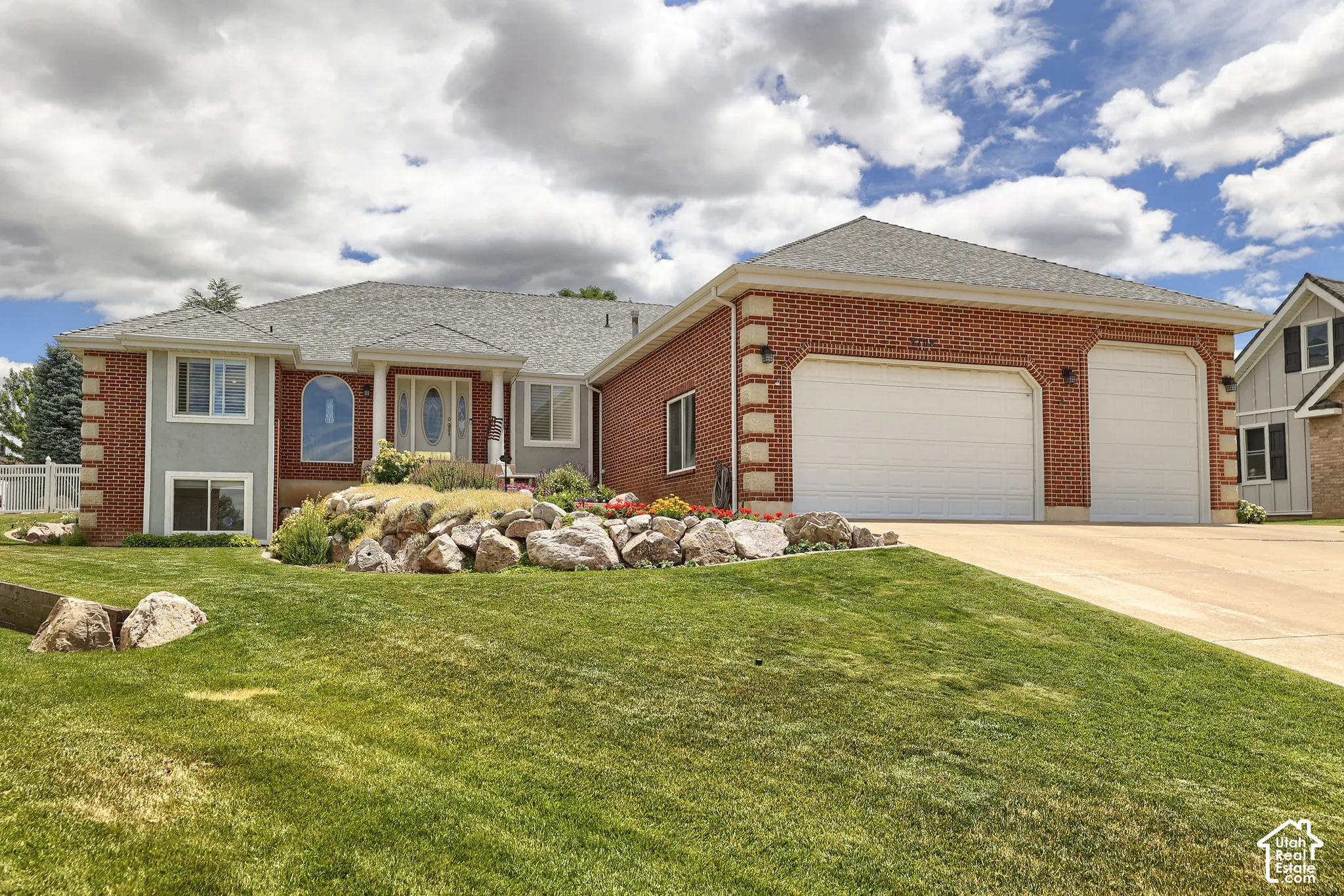 Brick and stucco exterior with a prominent three-car garage