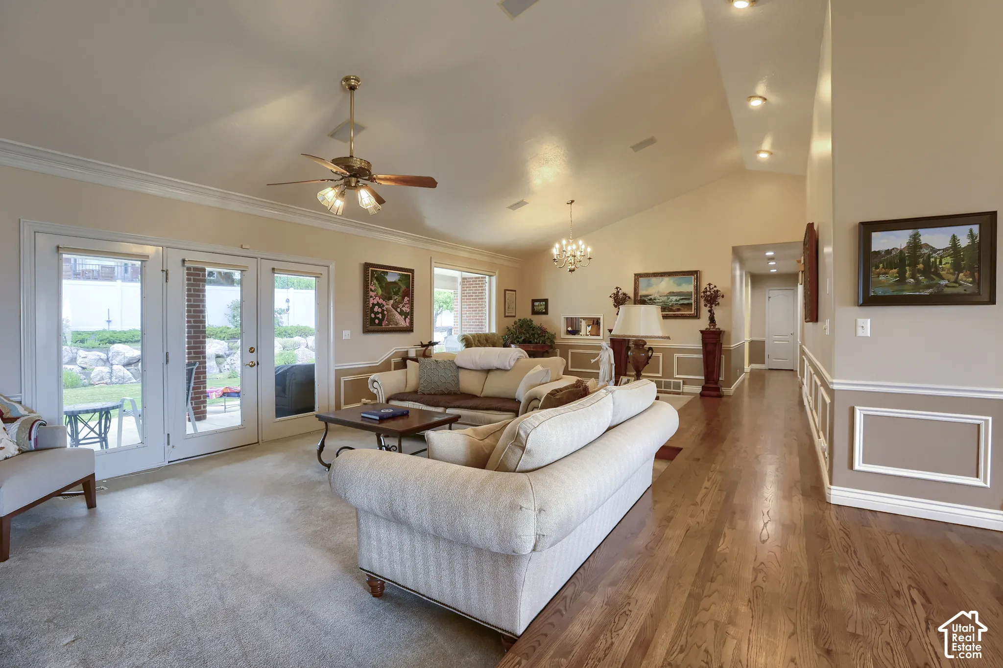 Vaulted ceiling living room featuring wood-finish flooring, recessed lighting, and crown molding