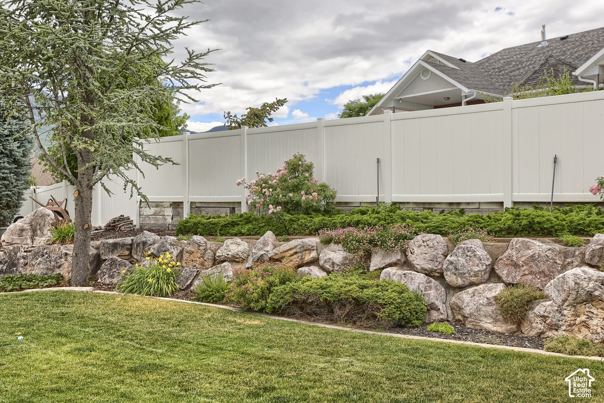 Expansive green lawn bordering a natural rock retaining wall