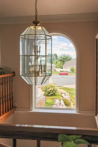 Ornate brass and glass chandelier illuminating an arched window