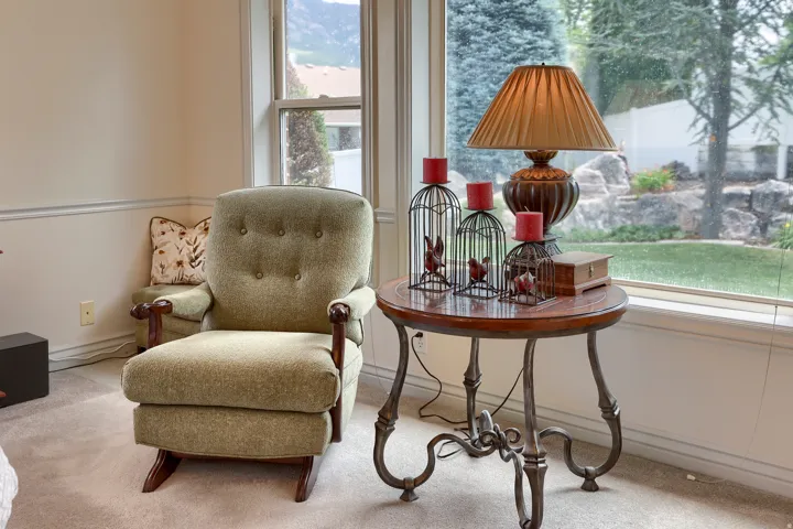 Bright interior space featuring large windows, neutral-toned walls with chair rail molding, and soft carpeting