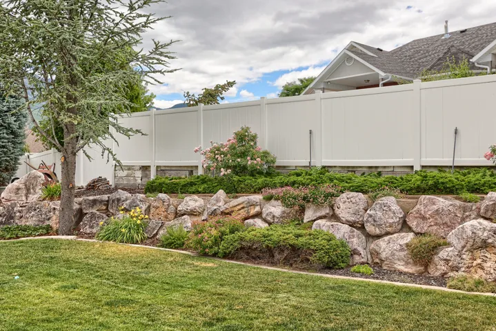 Expansive green lawn bordering a natural rock retaining wall