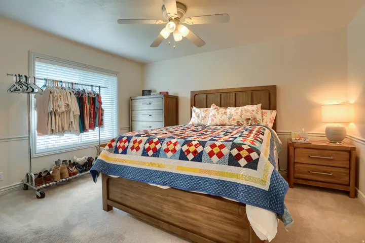 Carpeted bedroom featuring a ceiling fan, a window with blinds, and white wall trim
