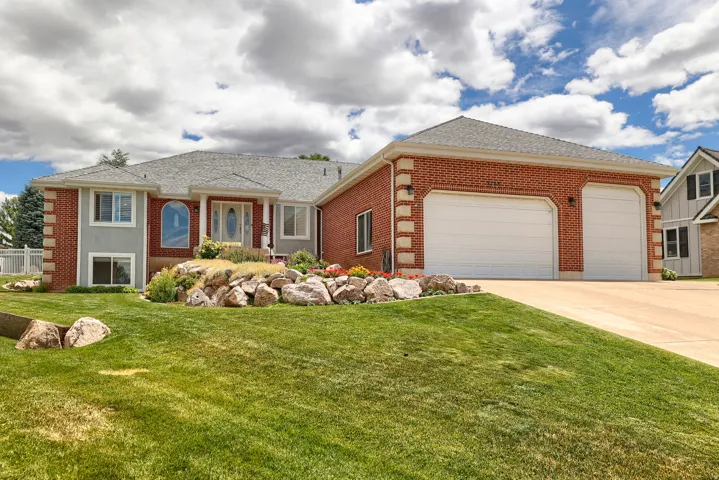 Brick and stucco exterior with a prominent three-car garage