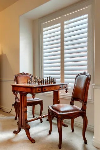Tall window with white plantation shutters and broad window casing