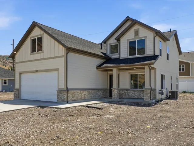 Modern two-story residence featuring a neutral exterior, stone veneer accents, and a covered front entry