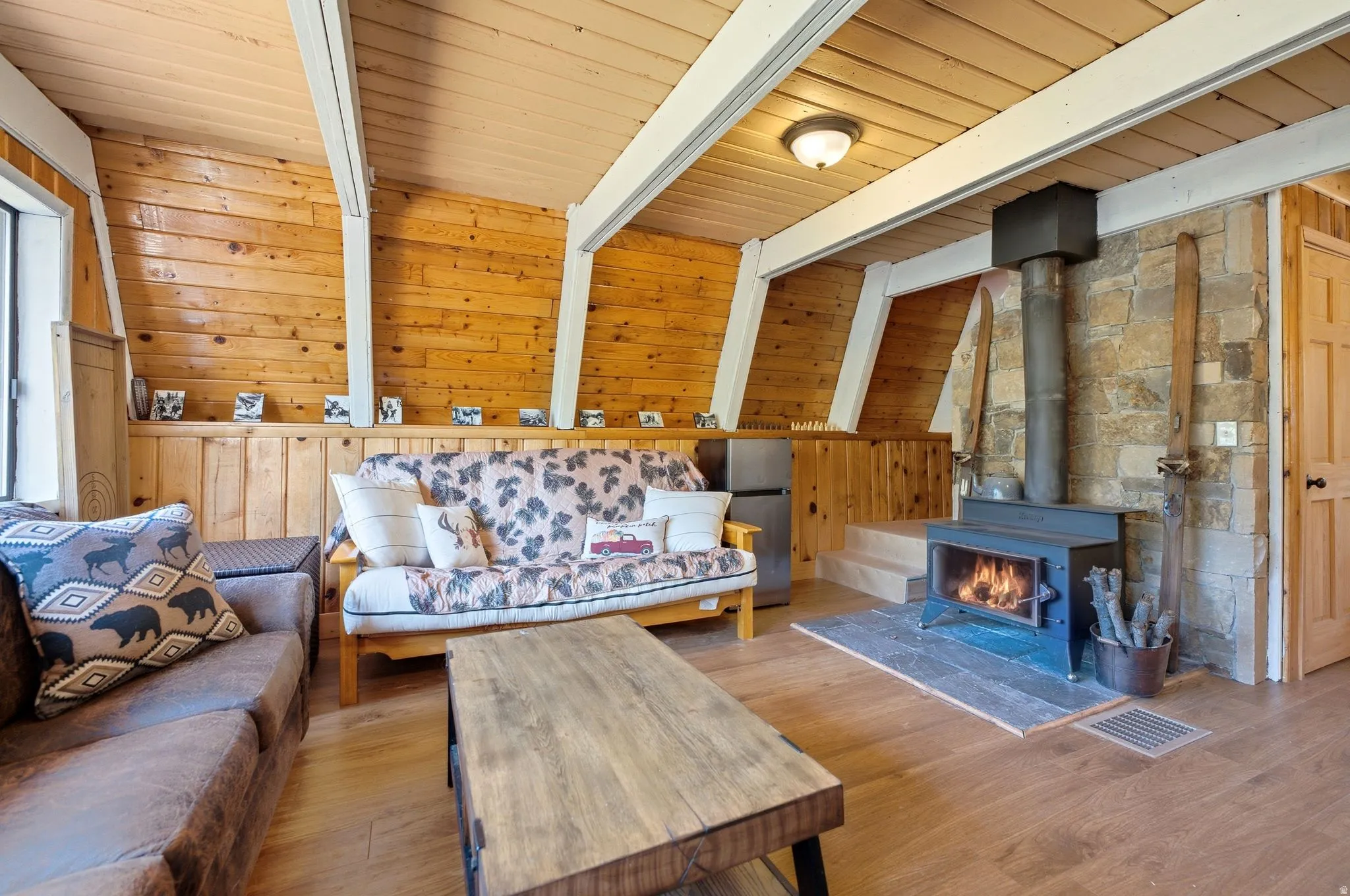Living area featuring a stone accent wall with a wood-burning stove.