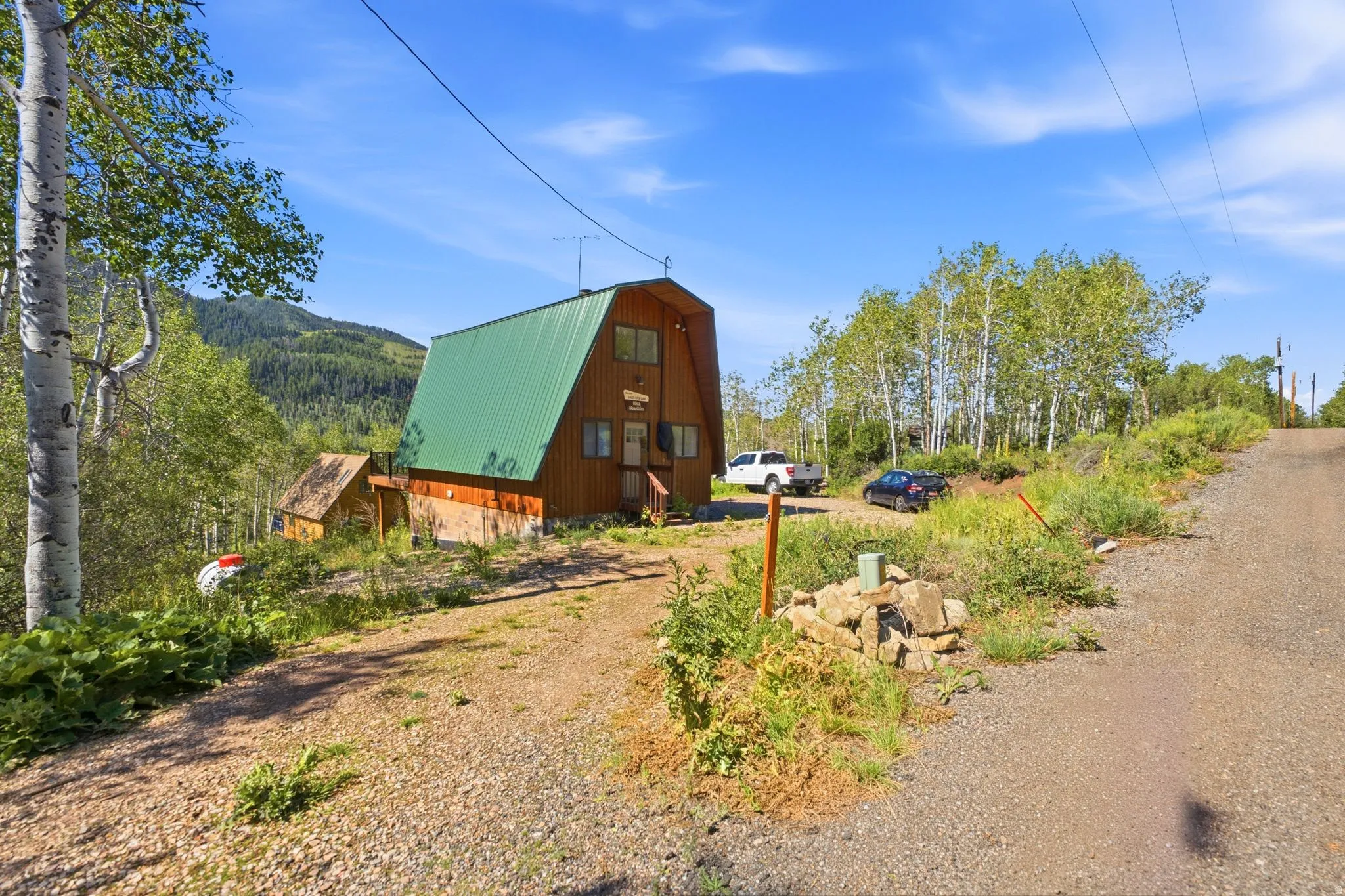 Wood-sided A-frame structure with a green metal roof