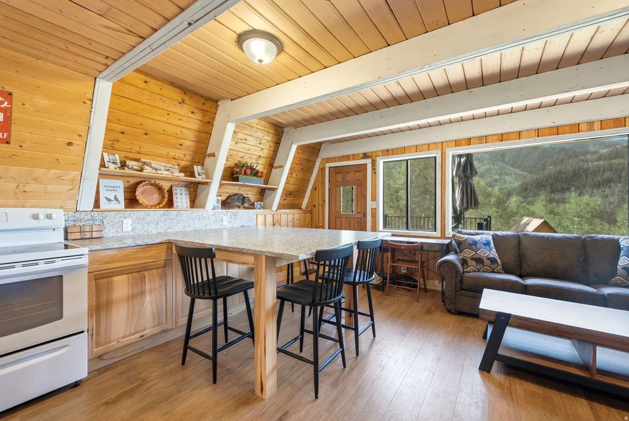 Open-concept living space with wood-finish flooring and extensive wood paneling throughout