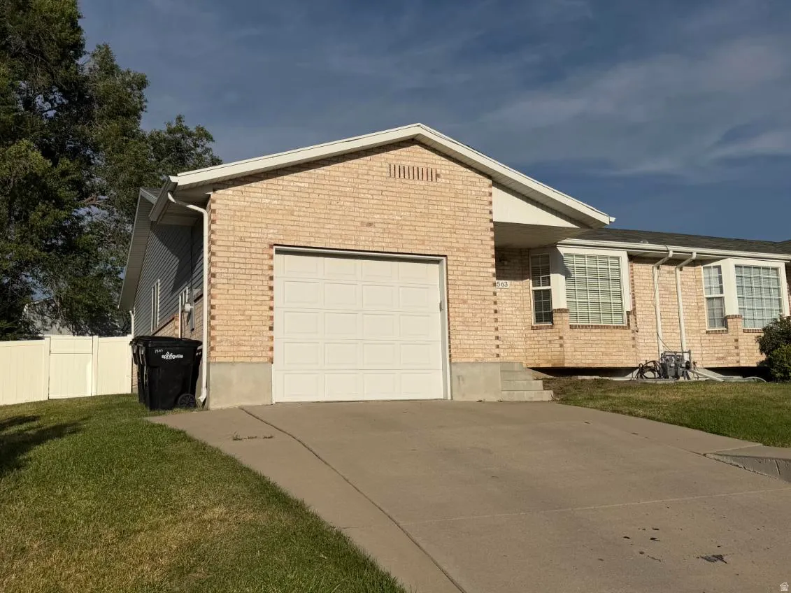 Light brick exterior with a white garage door