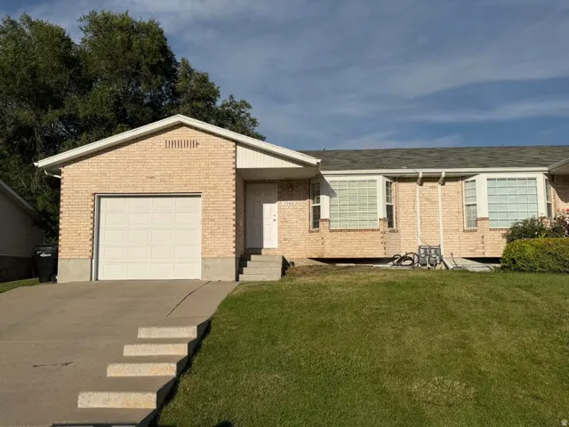 Brick exterior with a single-car garage and concrete driveway