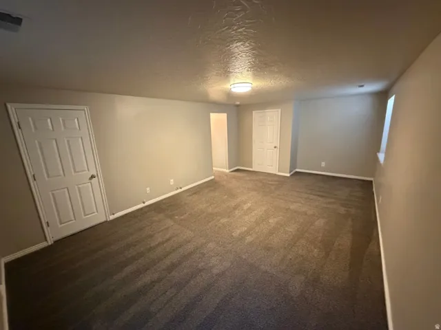 Carpeted room featuring neutral wall paint, white trim, and a flush-mount ceiling light fixture