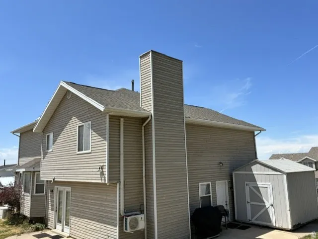 Exterior featuring horizontal siding, a gabled roofline, and a prominent chimney structure