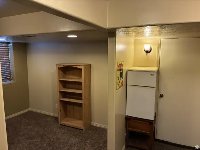 Carpeted room featuring a window with horizontal blinds and recessed lighting