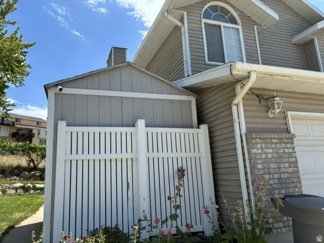 Exterior siding with a decorative arched window, a side storage shed, and a privacy fence