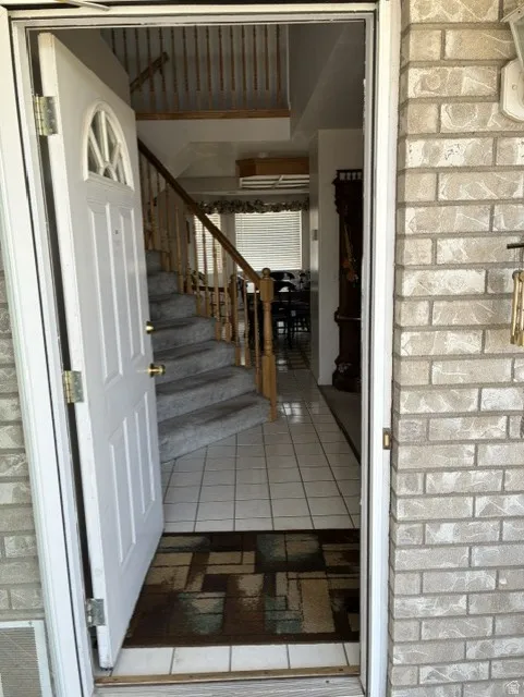 Light-colored brick exterior with a white entry door featuring an arched decorative window