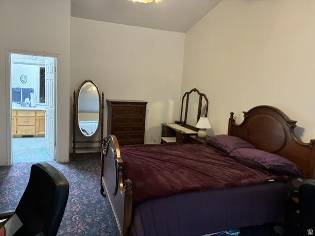 Carpeted room with a doorway leading to a separate area featuring wood-finish cabinetry and a countertop