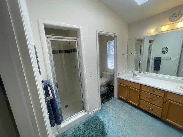 Dual vanity with integrated sinks, wood-finish cabinetry, and a full-width mirror