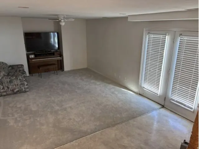 Neutral-toned walls complement the carpeted flooring