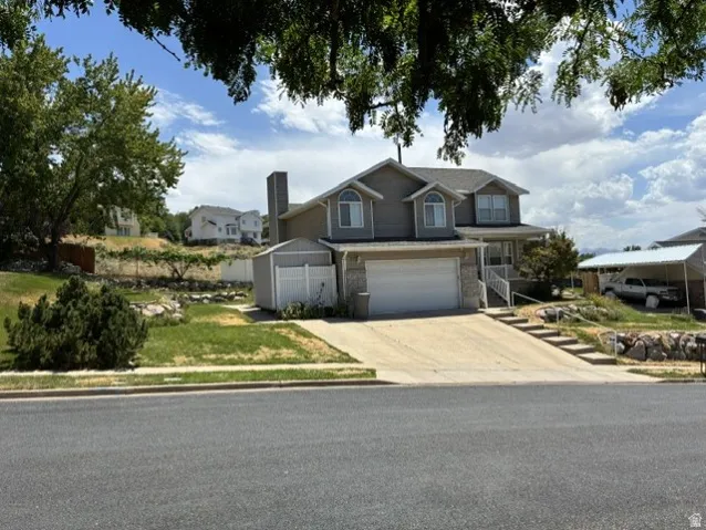 Two-story residence featuring a two-car garage, stone and siding exterior finishes, and a covered front porch