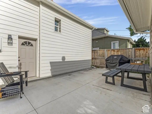 Shared patio that also functions as additional off street parking.  Paved patio area featuring concrete surfacing, a privacy fence, and an exterior door with an arched window insert
