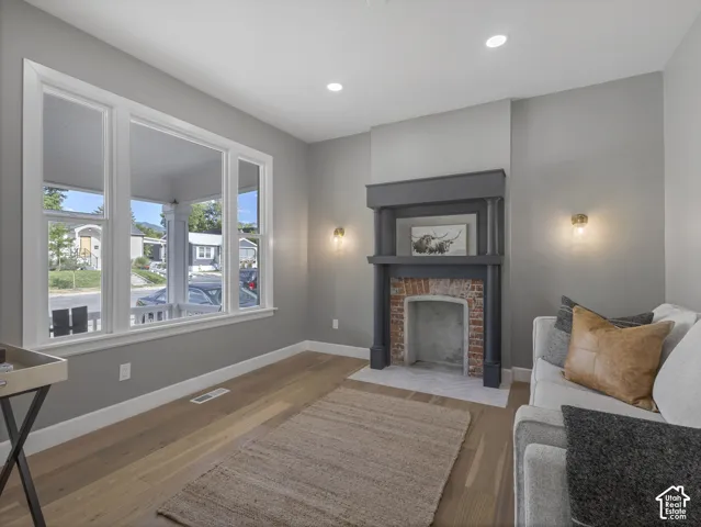 Home 1/2 -- 1046 S Lincoln Street -- Living space featuring a decorative fireplace with a brick firebox, dark wood mantel, and herringbone tile hearth