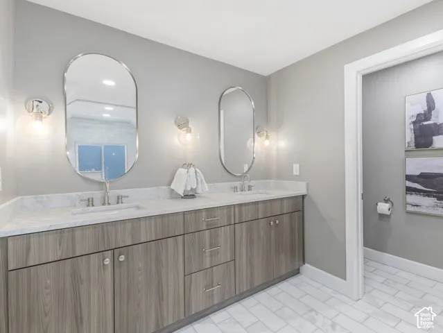 Home 1/2 -- 1046 S Lincoln Street -- Double vanity featuring a light wood-finish cabinetry, white countertop, and dual oval mirrors with sconce lighting