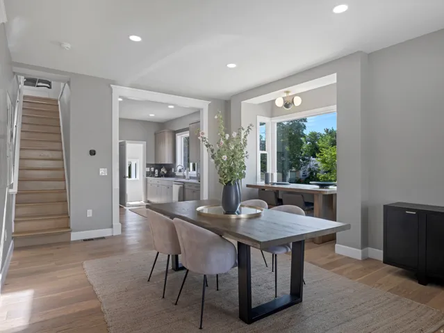 Dining area featuring wood-finish flooring, recessed lighting, and a broad window with exterior scenery