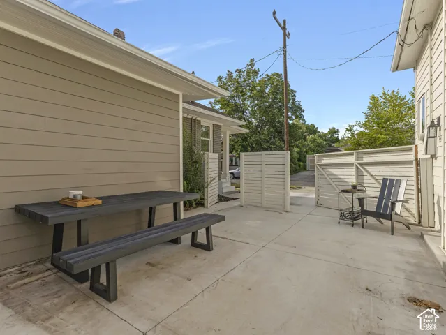 Shared patio that also functions as additional off street parking.  Concrete patio area featuring a slatted privacy fence and exterior siding