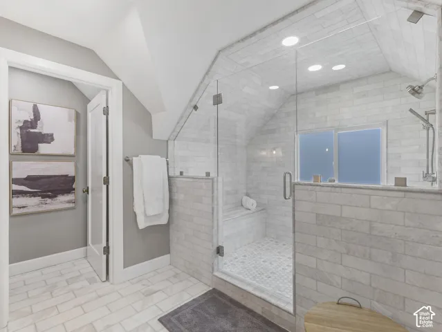Home 1/2 -- 1046 S Lincoln Street --Spacious bathroom featuring a glass-enclosed shower with a built-in bench, full-height tile surround, and dual shower heads