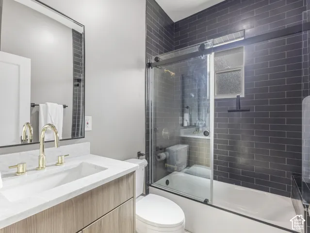 Home 1/2 -- 1046 S Lincoln Street -- Contemporary bathroom featuring a wood-finish vanity with a white countertop and brass-finish fixtures