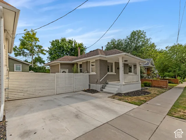Home 2/2 - 938 E Herbert Avenue -- Exterior showcasing a brick facade, covered porch with white columns, and a concrete driveway