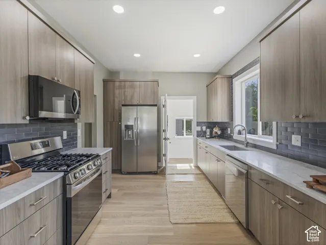 Home 1/2 -- 1046 S Lincoln Street --Modern galley kitchen featuring light wood-finish cabinetry, stainless steel appliances, a subway tile backsplash, and recessed lighting