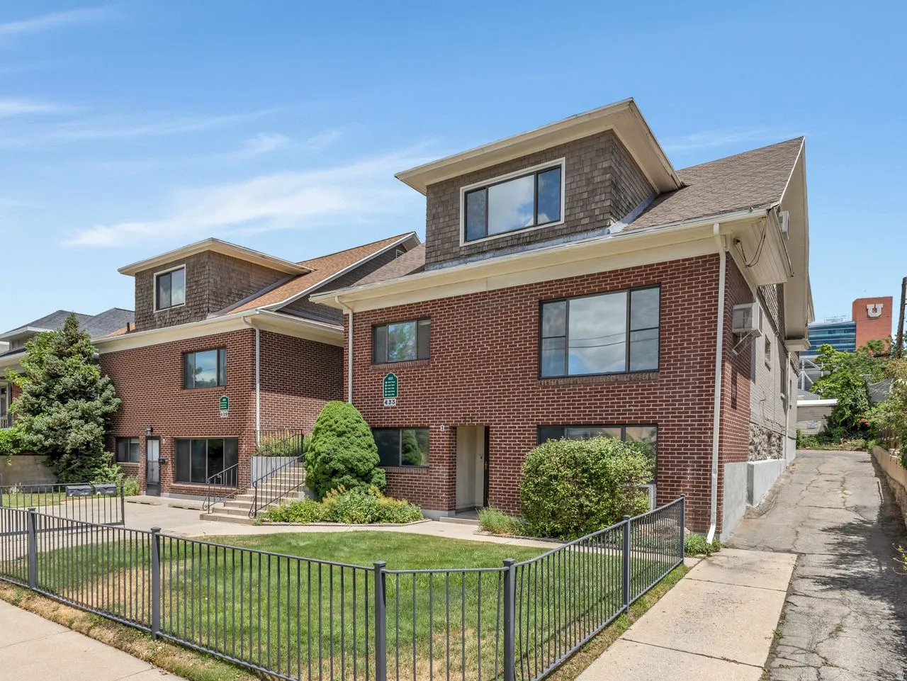 Brick exterior with a dormer roofline and dark-framed windows