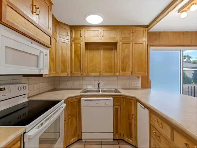 Kitchen featuring abundant wood cabinetry, light countertops, and a tile backsplash