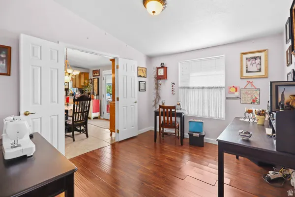 Interior room featuring wood-finish flooring, light-colored walls, and a ceiling-mounted light fixture