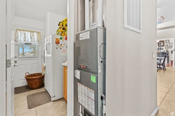 Utility area featuring a furnace system, tiled flooring, and a white exterior door with a window