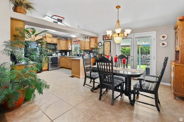 Open-concept dining area with tile flooring and a multi-light chandelier