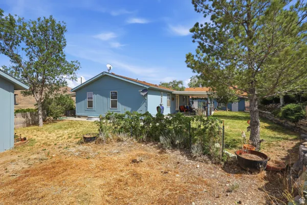 Rear exterior of the property featuring light blue siding and multiple windows