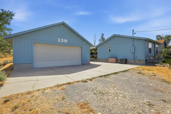 Detached garage featuring a wide garage door, light blue siding, and concrete foundation