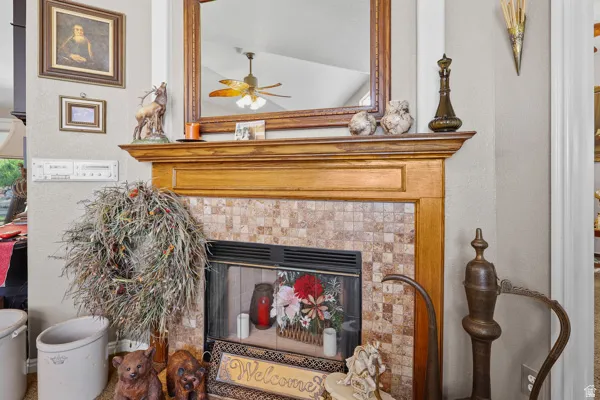 Fireplace featuring a natural wood mantel, mosaic tile surround, and an integrated firebox