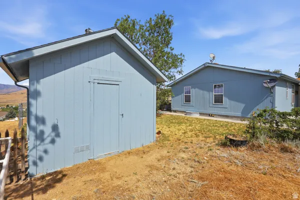Light blue storage shed with a single entry door and a sloped roofline